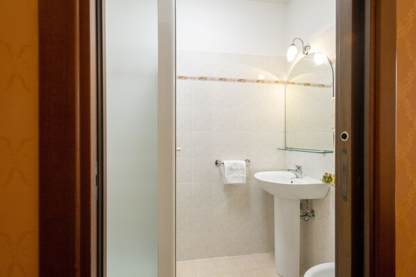 A bathroom with a sink, mirror, and towel rack. - Hotel Boccaccio (Florence)