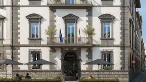 A multi-story building with a symmetrical facade, large windows, and a central entrance with steps. - Il Malaspina (Florence)