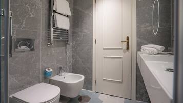 A modern bathroom with a bidet, toilet, and a large sink.