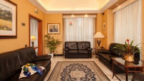 A well-lit living room with a large rug, two sofas, and a coffee table.