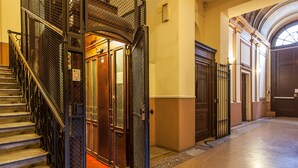 A grand staircase with a metal railing leading to a wooden door.