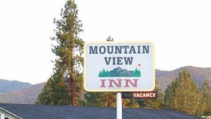 A Mountain View Inn sign with a mountain graphic and a 'No Vacancy' sign below it.