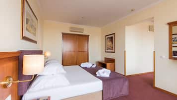Une chambre d’hôtel avec un lit, une table de chevet avec une lampe, une télécommande et des serviettes sur le lit.
