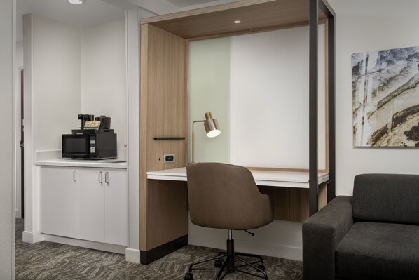 Un espace de bureau moderne comprenant un bureau, un fauteuil de bureau et une machine à café.