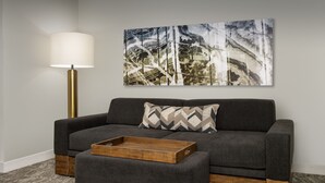 Una sala de estar moderna con un sofá gris, una mesita de madera y una lámpara de pie.