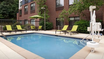 Una piscina al aire libre de temporada, sillones reclinables de piscina