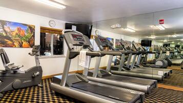 A gym with treadmills, stationary bikes, and exercise equipment.