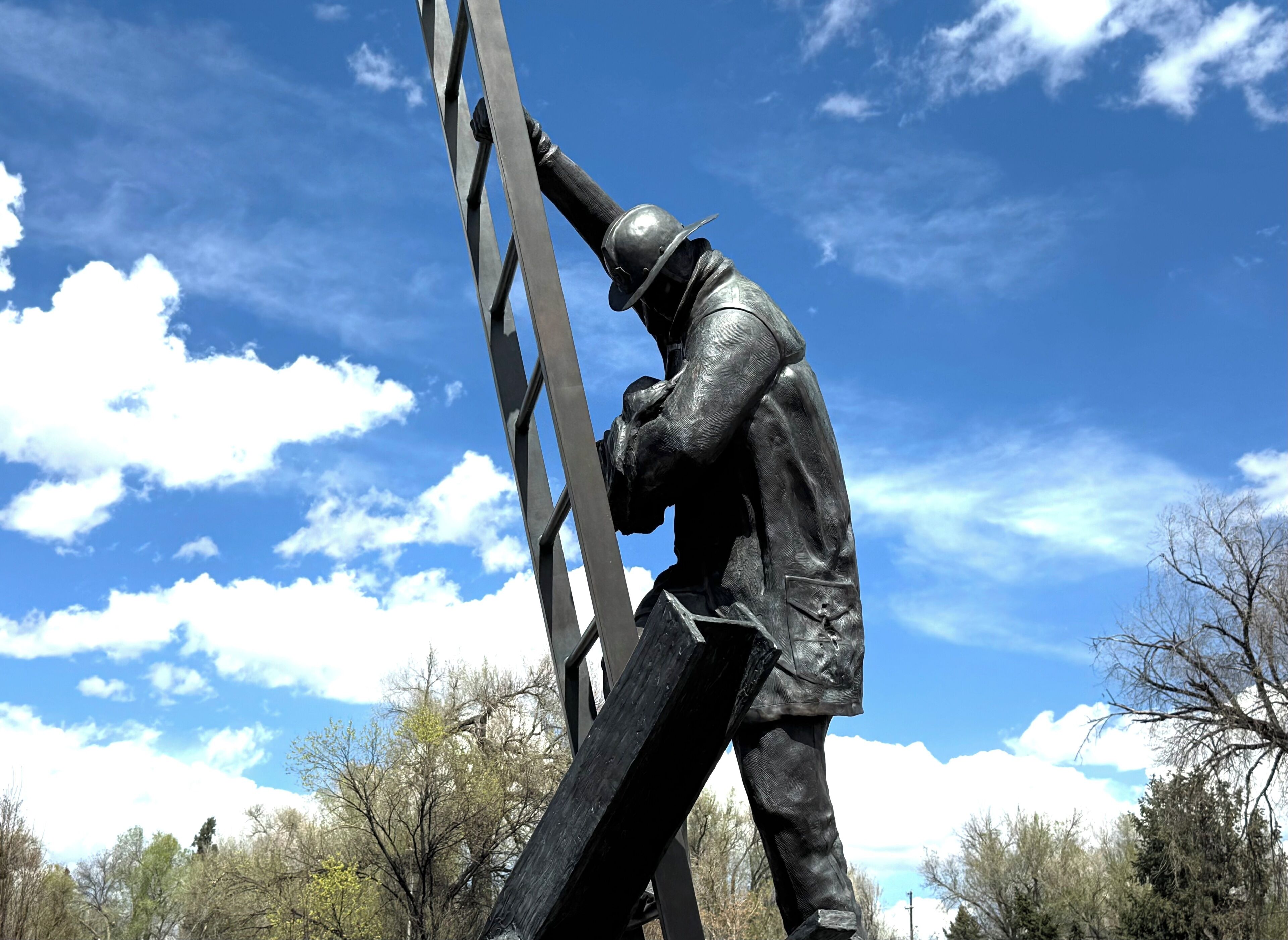 A statue of a person climbing a ladder.