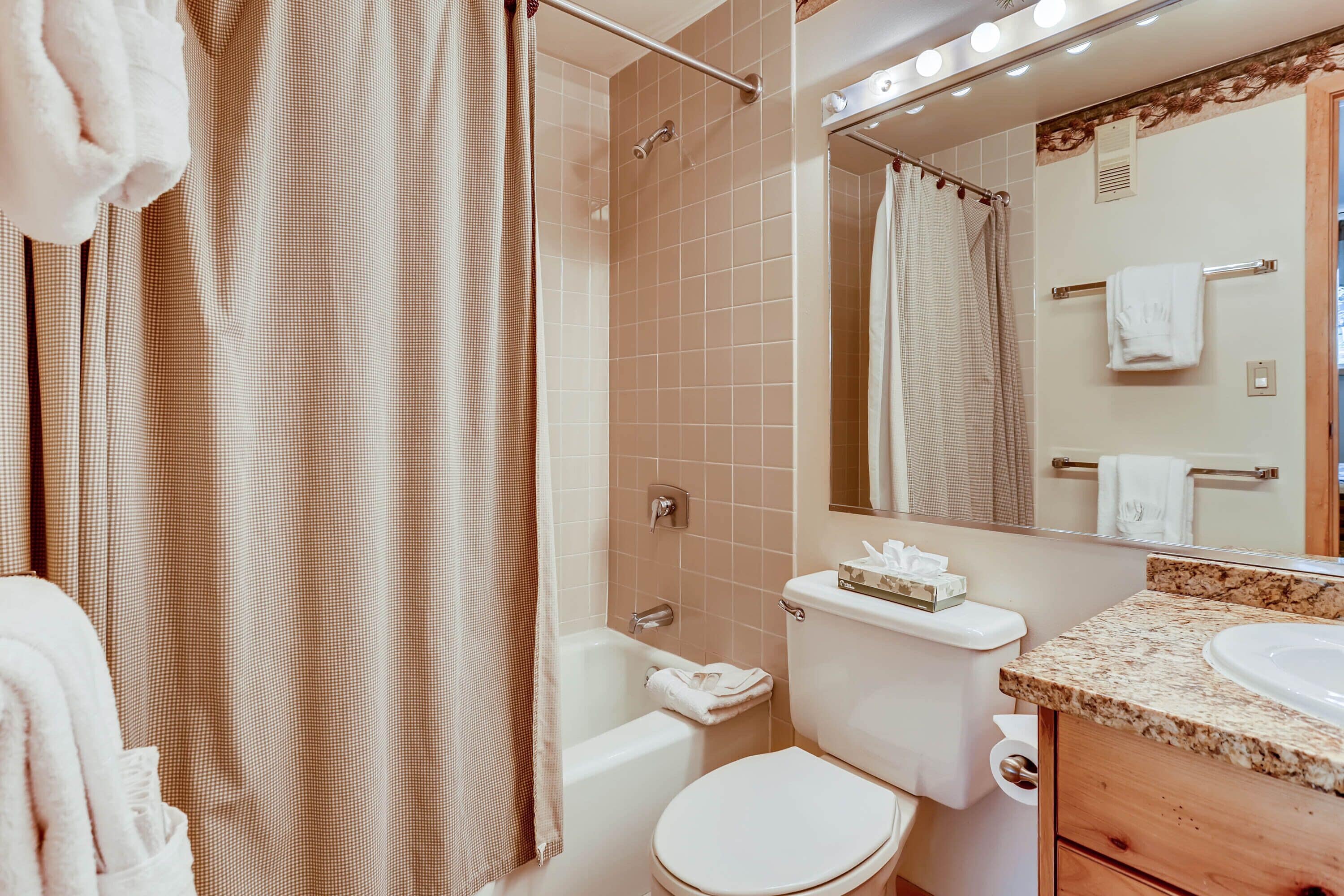 A bathroom with a bathtub, toilet, and sink.