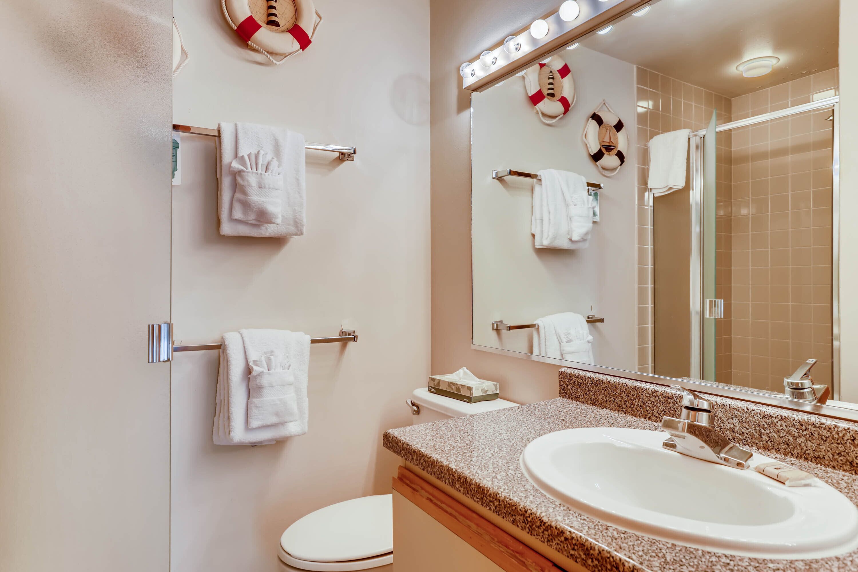 A bathroom with a sink, toilet, and towel racks.