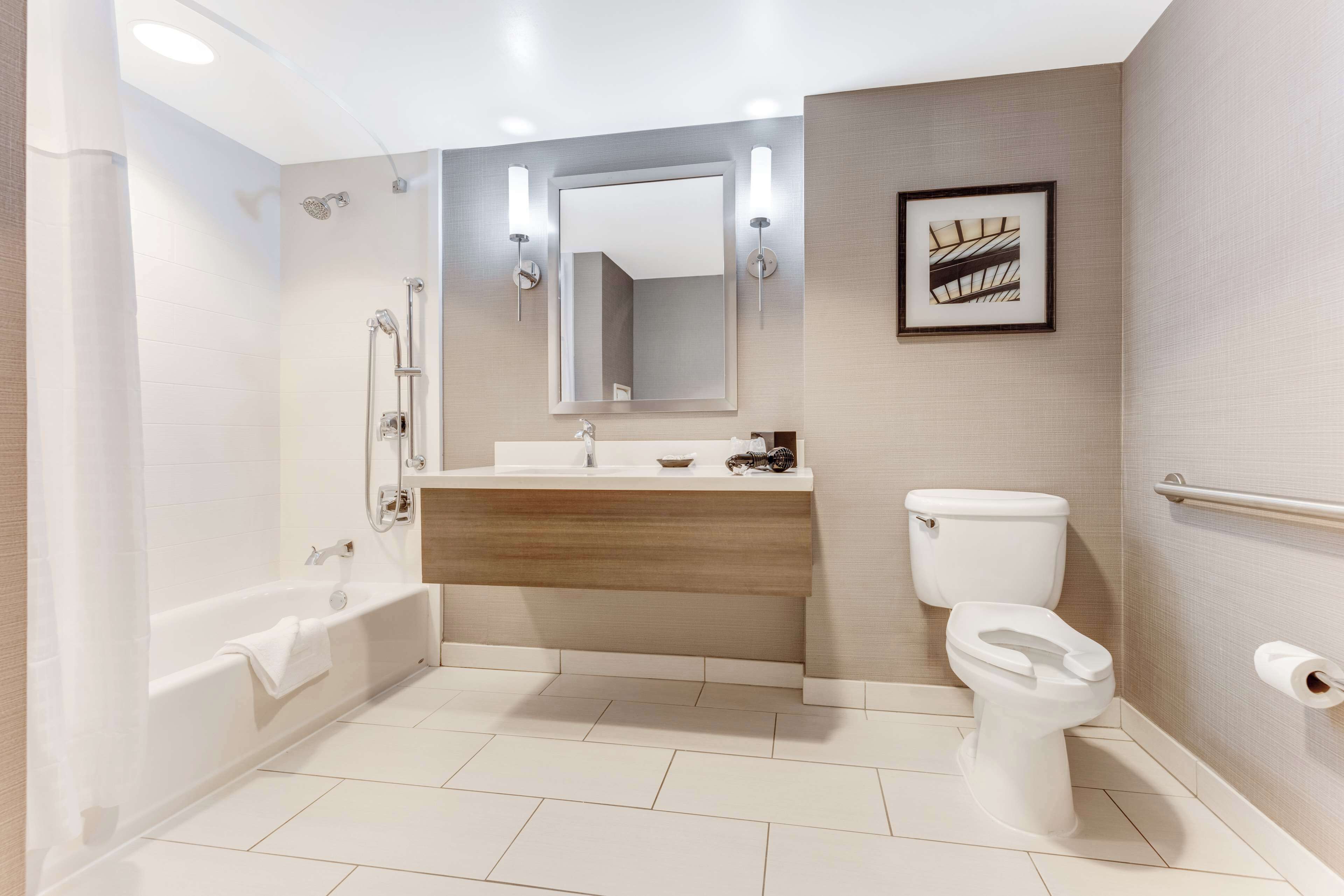Une salle de bain moderne équipée d’une baignoire, de toilettes et d’un meuble-lavabo.