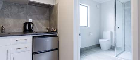 A modern kitchen with a stainless steel refrigerator, a coffee maker, and a microwave.