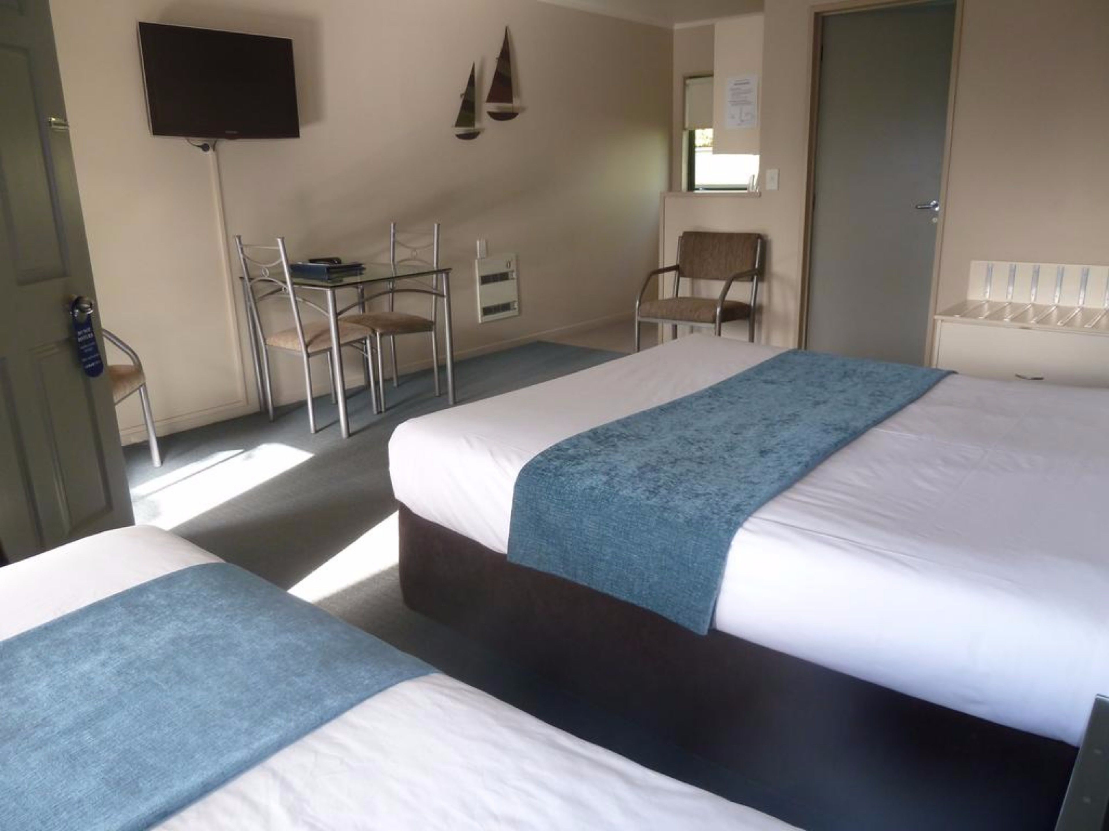 Una habitación de hotel con dos camas, un escritorio y una silla.