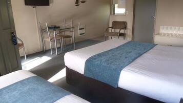 Una habitación de hotel con dos camas, un escritorio y una silla.