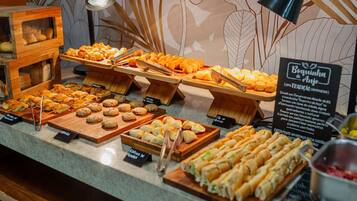 Un buffet proposant diverses pâtisseries et une pancarte indiquant un plat traditionnel.