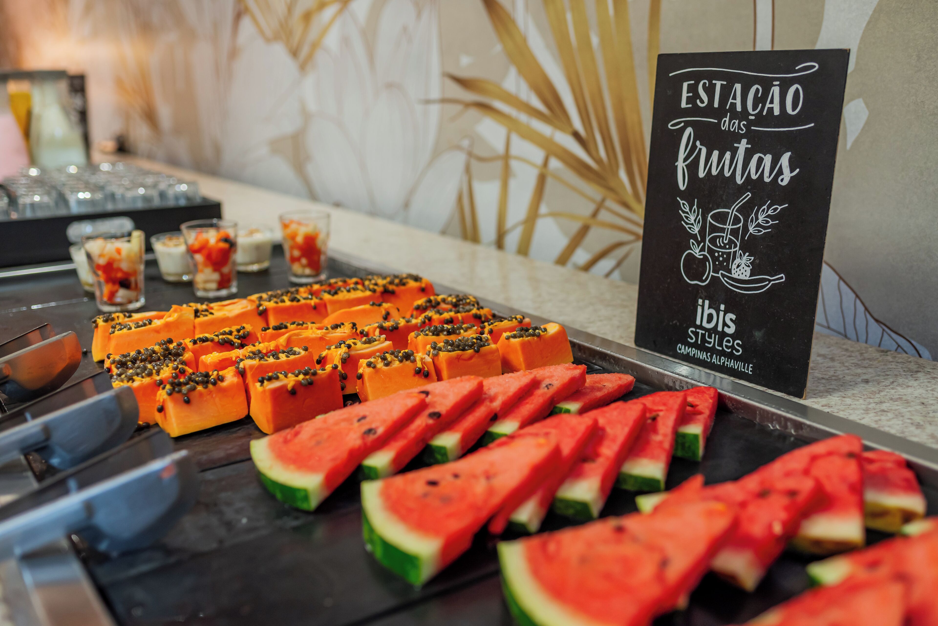 Une table de buffet proposant une variété de fruits et de boissons.