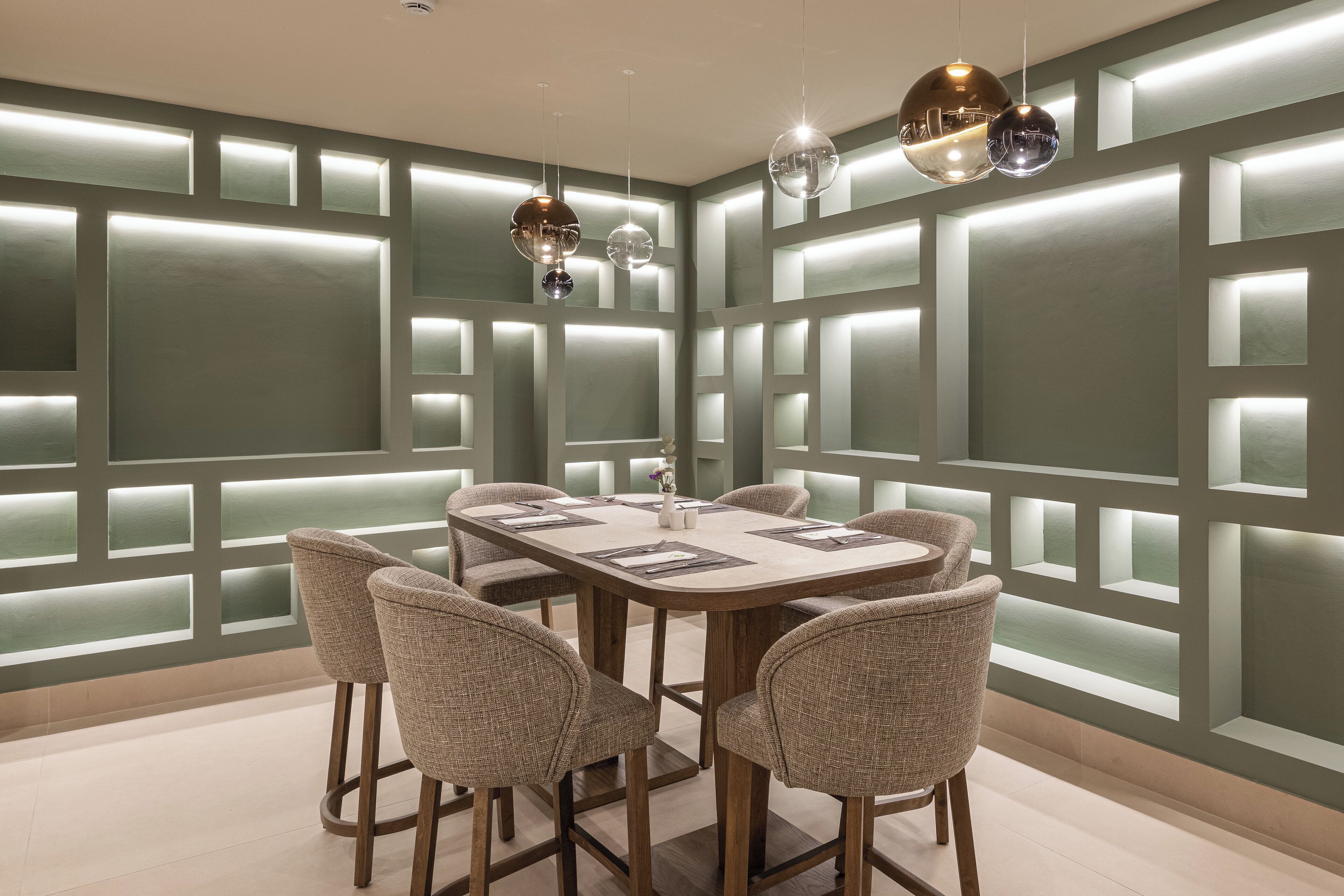 Een moderne eetruimte met een rechthoekige tafel, zes stoelen en hanglampen.