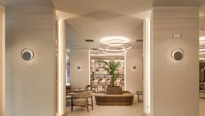 A modern interior with a central seating area, a plant, and a well-lit ceiling design. - Holiday Inn Thessaloniki by IHG (Thessaloniki)