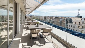 A rooftop terrace with a table and chairs, overlooking a cityscape. - Holiday Inn Thessaloniki by IHG (Thessaloniki)