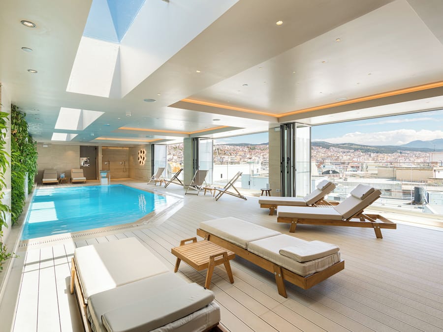 Una piscina techada, sillones reclinables de piscina