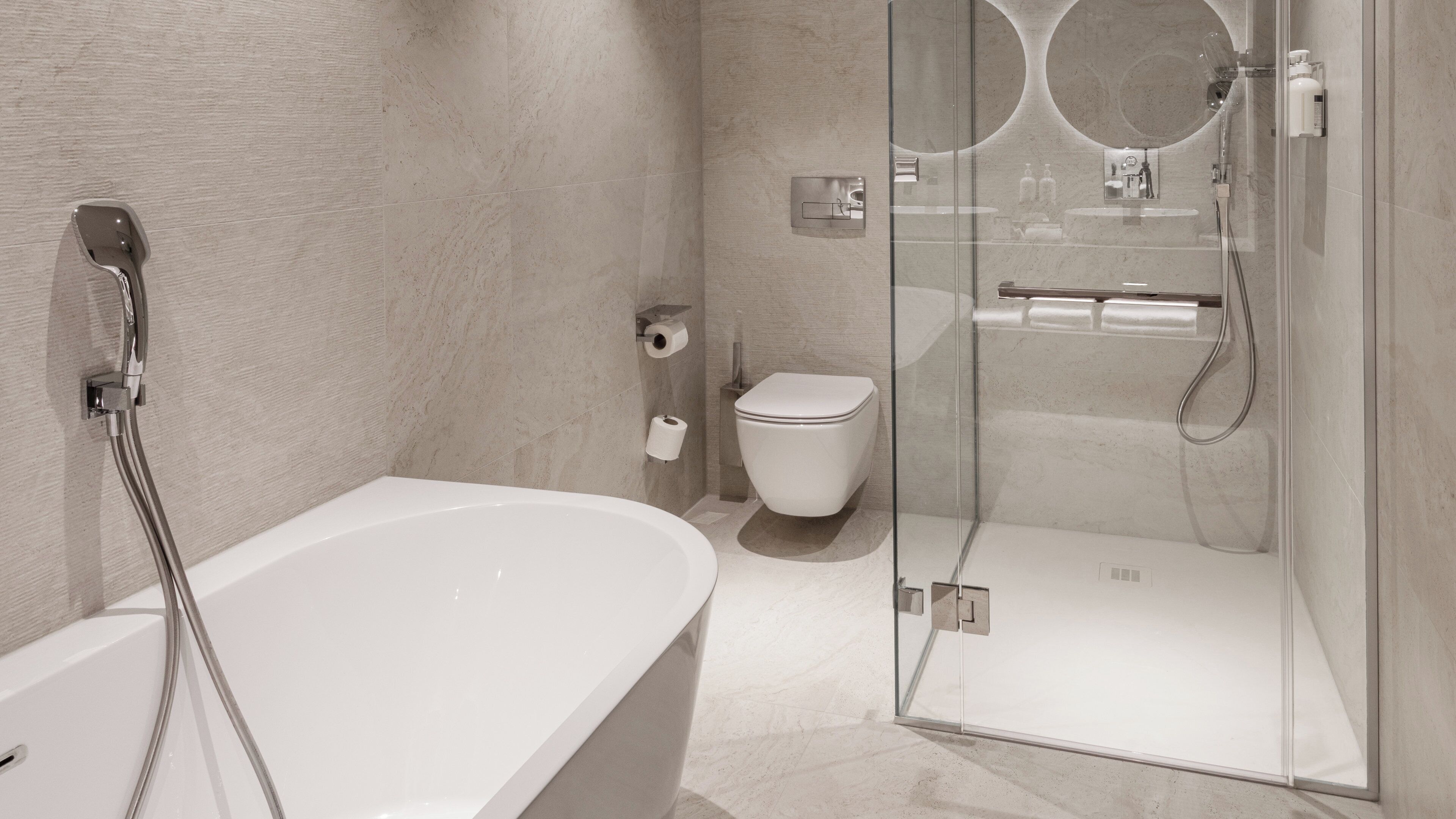 A modern bathroom with a freestanding bathtub, a glass-enclosed shower area, and a toilet.