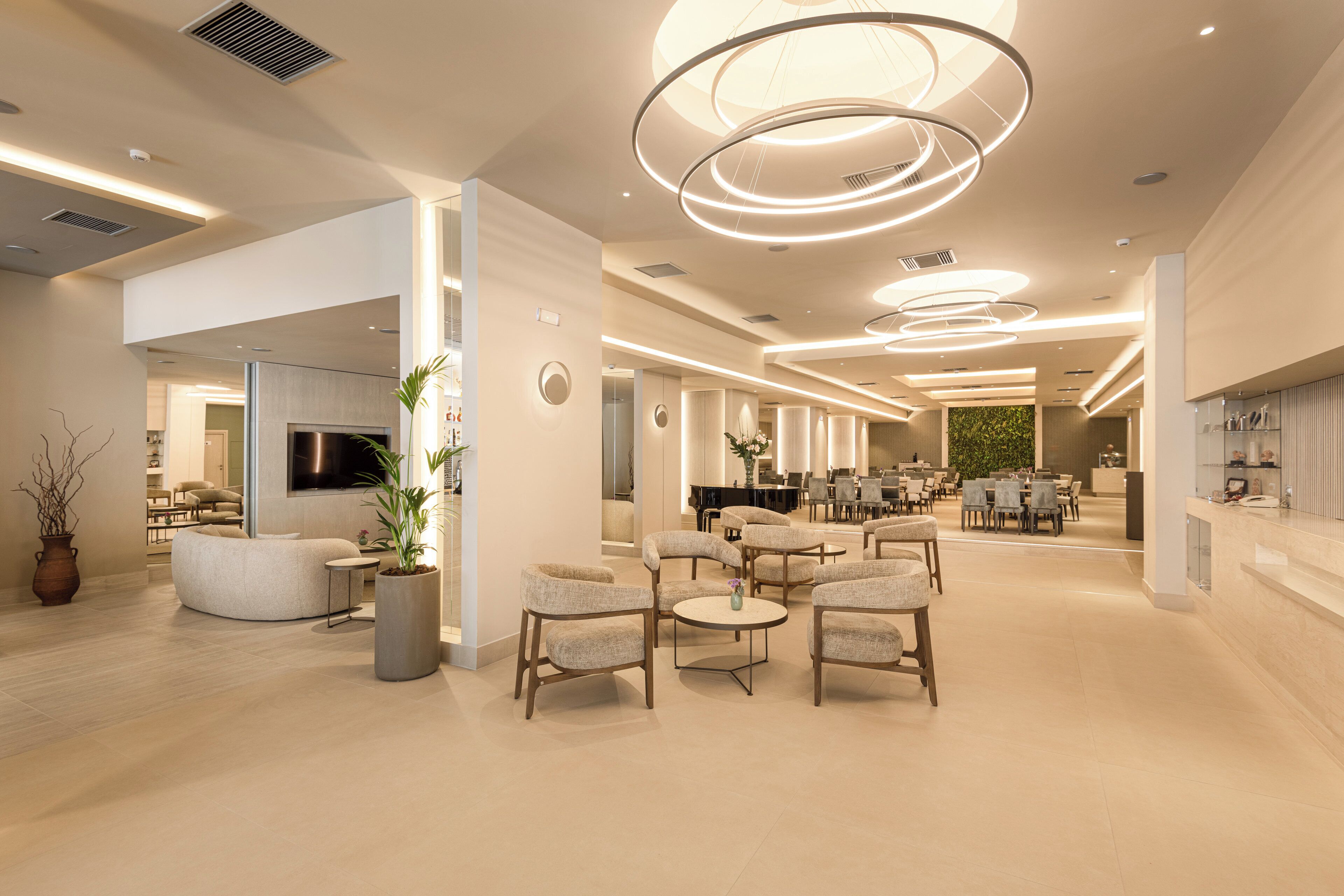 A spacious lobby with modern furniture, a central seating area, and a reception desk.