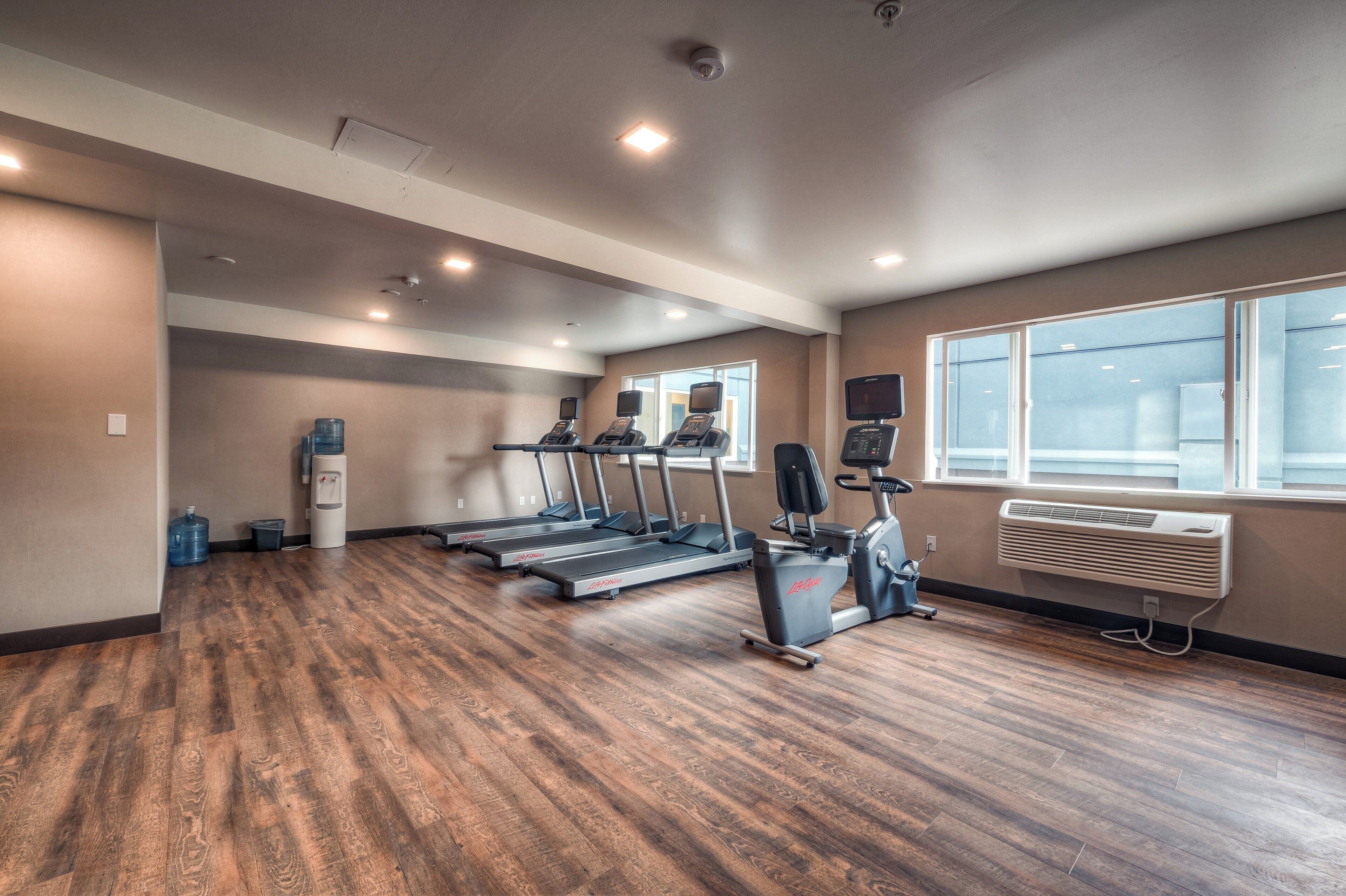 A gym with treadmills, a stationary bike, and a water dispenser.