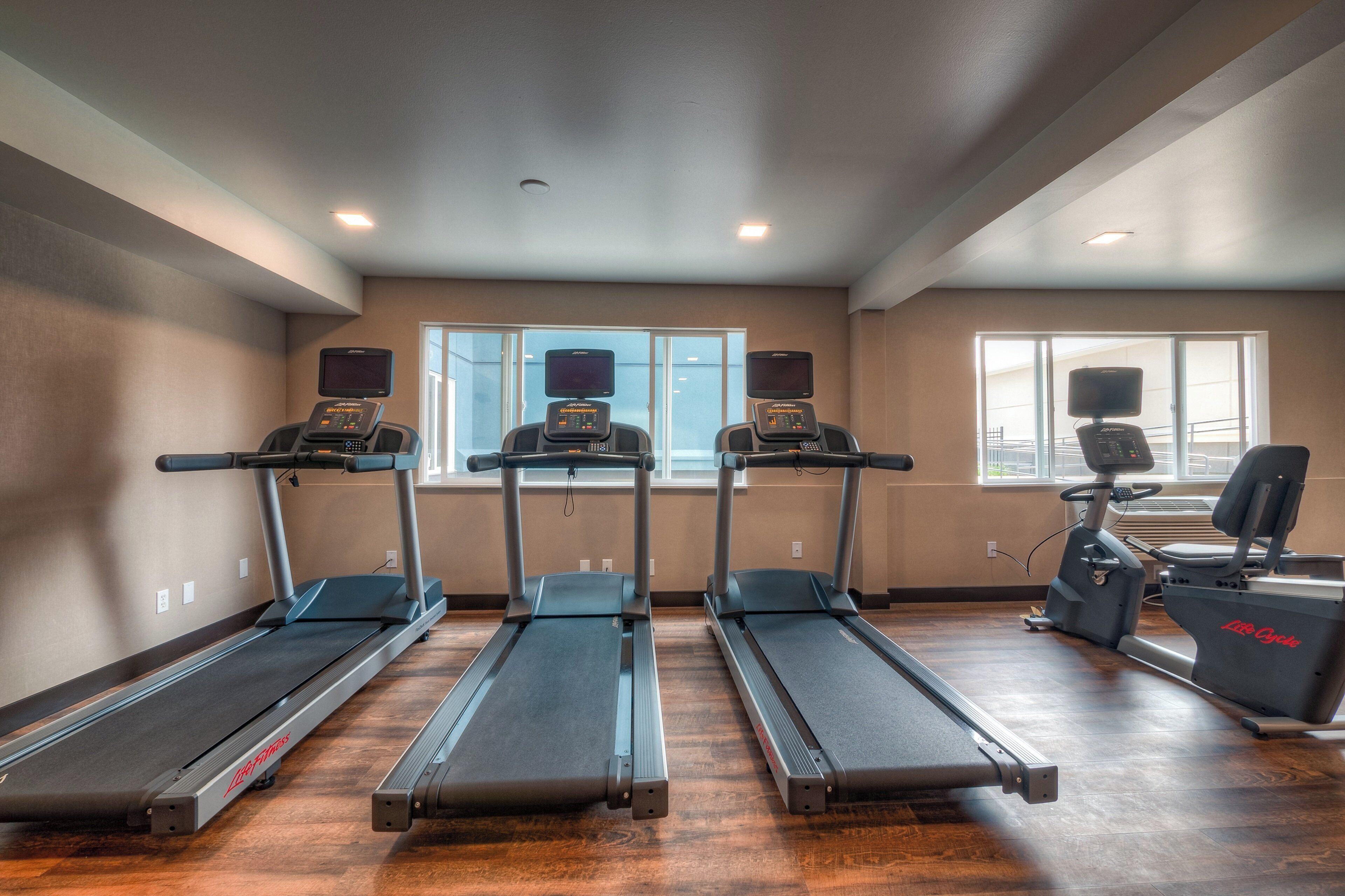 A fitness room with treadmills, a stationary bike, and a rowing machine.