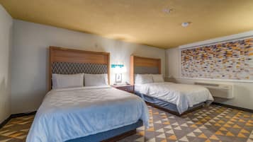 A hotel room with two beds, a patterned floor, and a wall with geometric artwork.