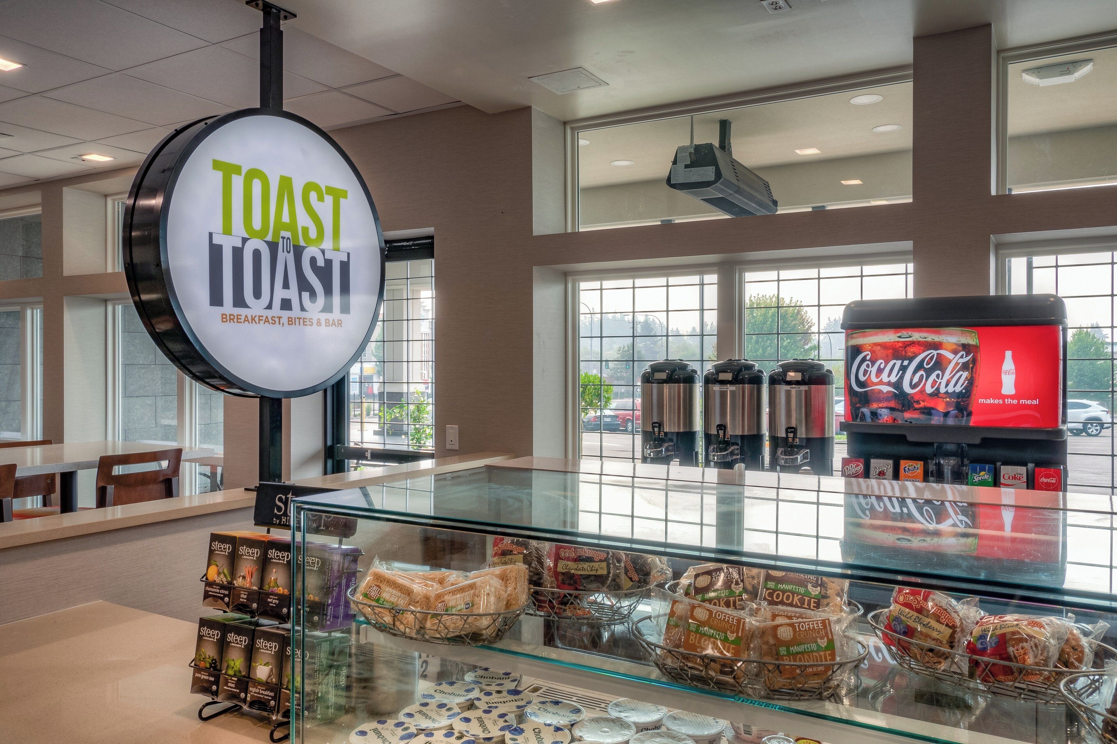 A breakfast area with a sign reading 'TOAST TO TOAST' and a display of various breakfast items.