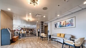 A hotel lobby with a reception desk, seating area, and a dining section. - Holiday Inn Tacoma Mall by IHG (Tacoma)