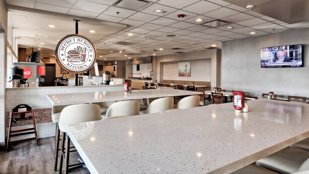 A spacious restaurant with a long counter and multiple seating areas. - Holiday Inn Tacoma Mall by IHG (Tacoma)