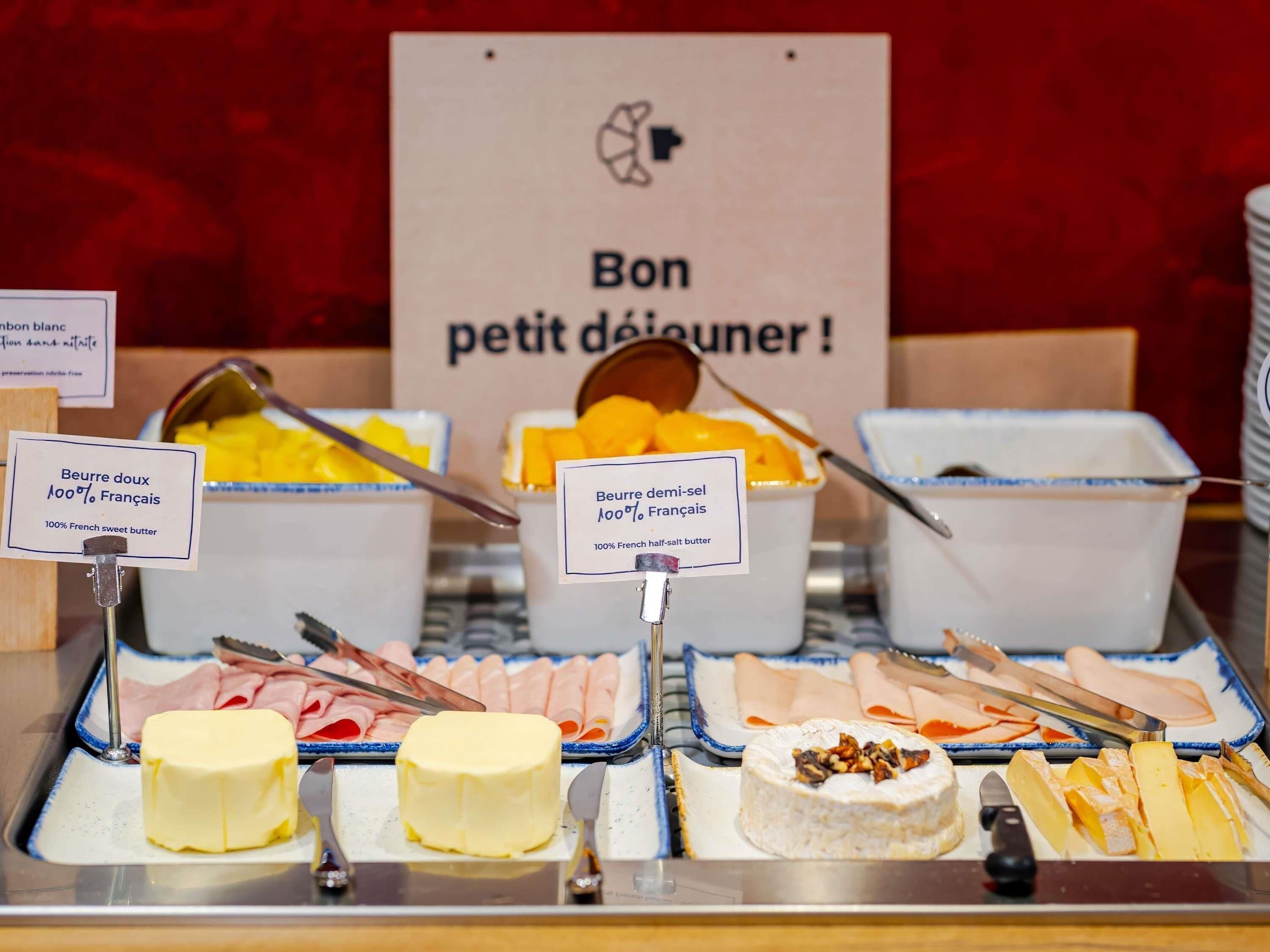A buffet with various food items including butter, cheese, and meats.