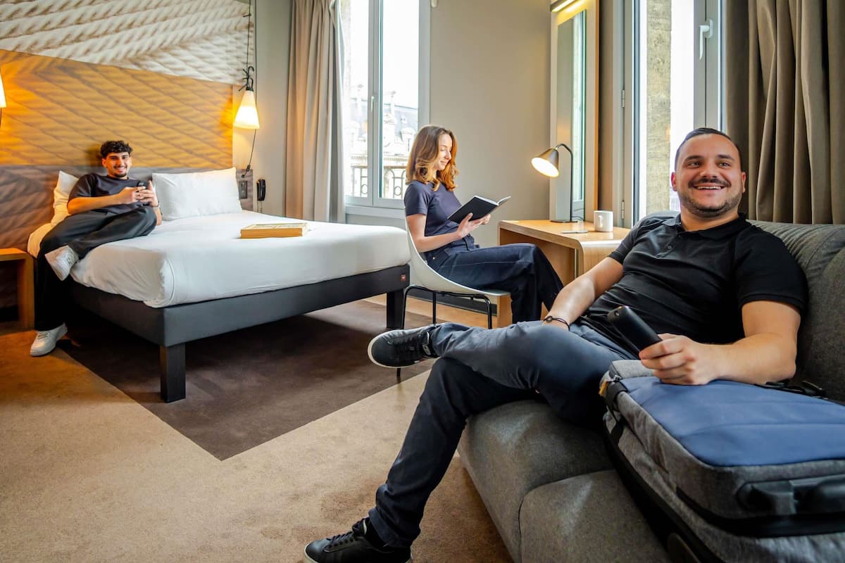 Een hotelkamer met een bed, een bank, een bureau en een stoel.