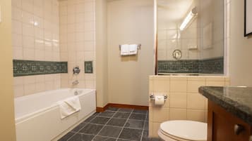 A bathroom with a bathtub, toilet, and a mirror.