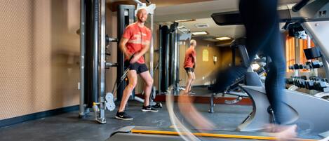 A gym with exercise equipment, including a treadmill and weight machines.