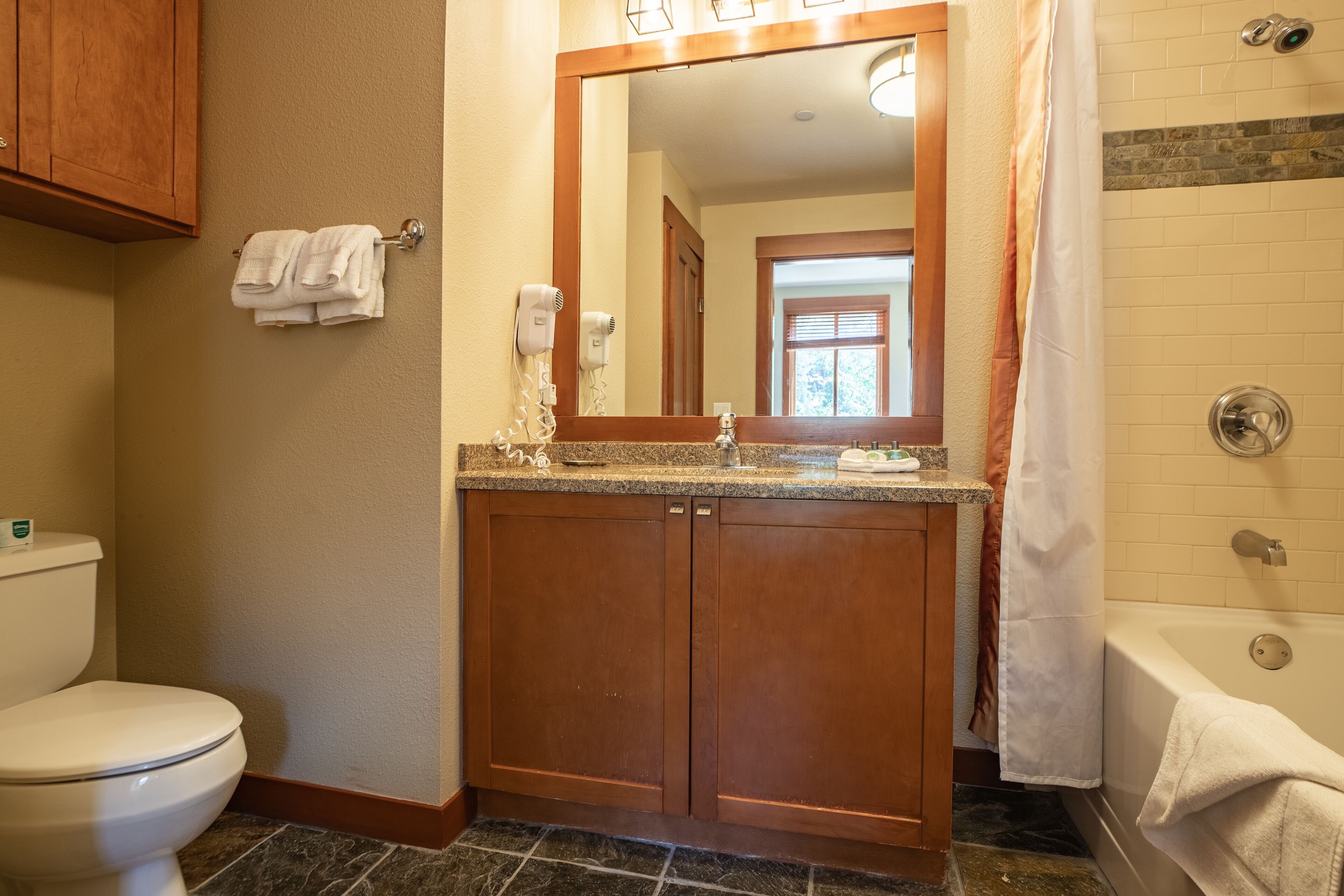 A bathroom with a toilet, vanity, and bathtub.