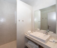 Un baño moderno con un espejo grande, un lavabo y un perchero para toallas.