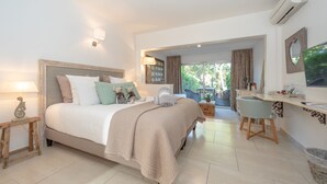 Quarto com cama, mesas de cabeceira, escrivaninha e cadeira.