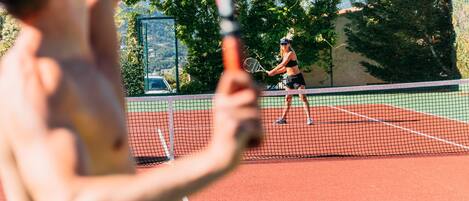 A tennis court with two players in action.