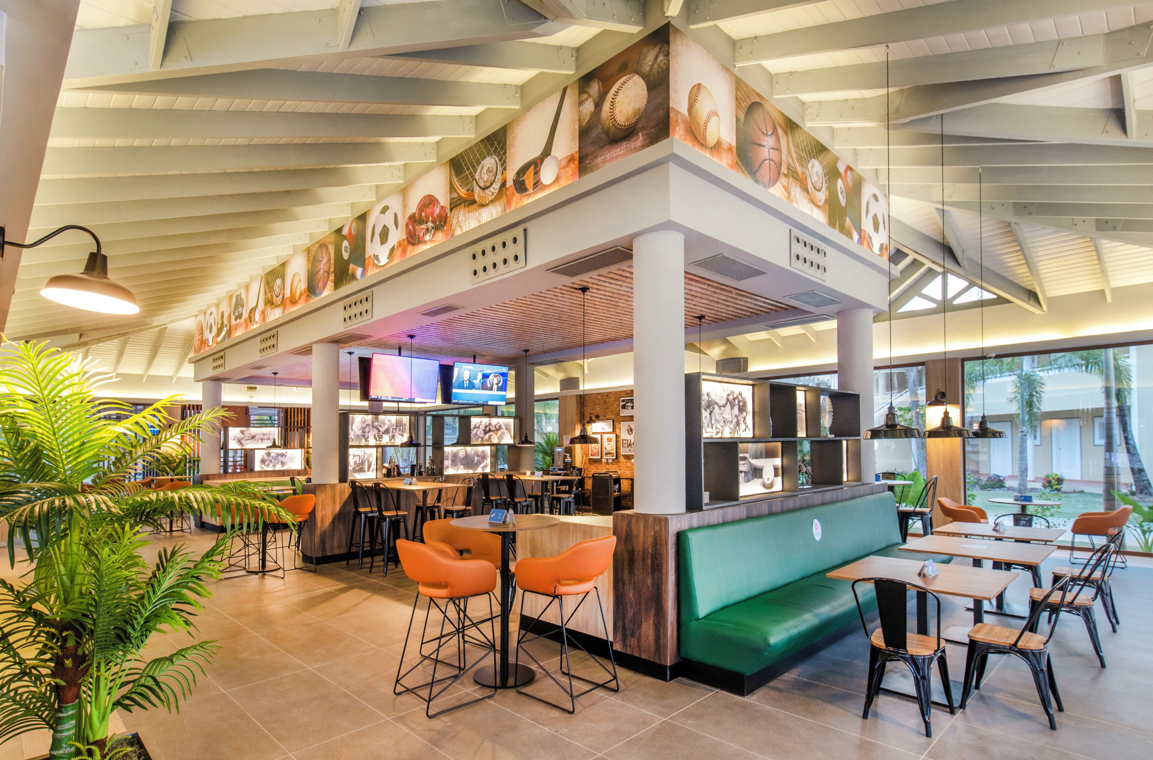 A restaurant with a counter, bar seating, and a green booth area.