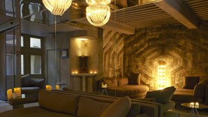 A modern living room with a stone fireplace, comfortable seating, and ambient lighting.
