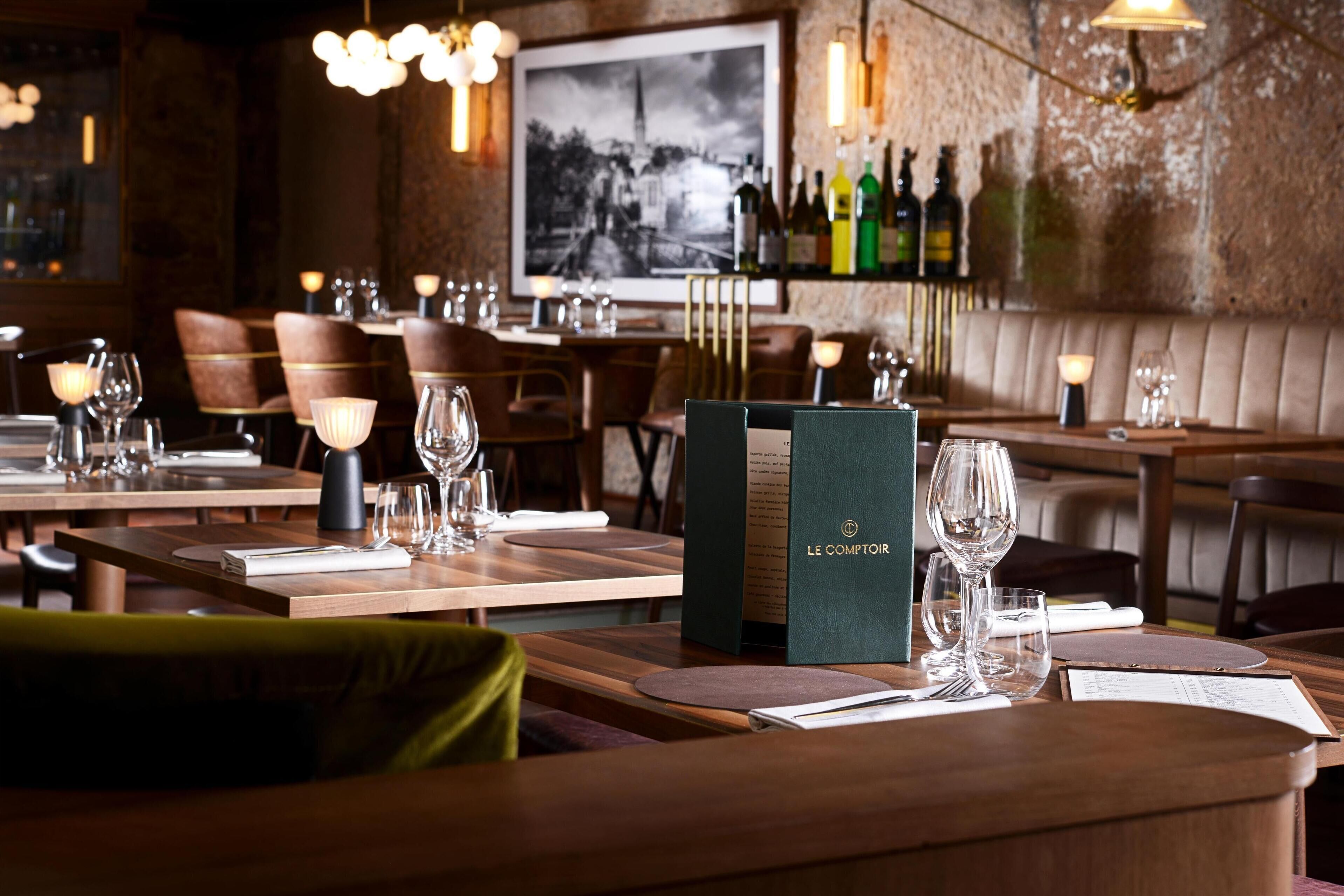 A restaurant interior with wooden tables, chairs, and a menu stand.