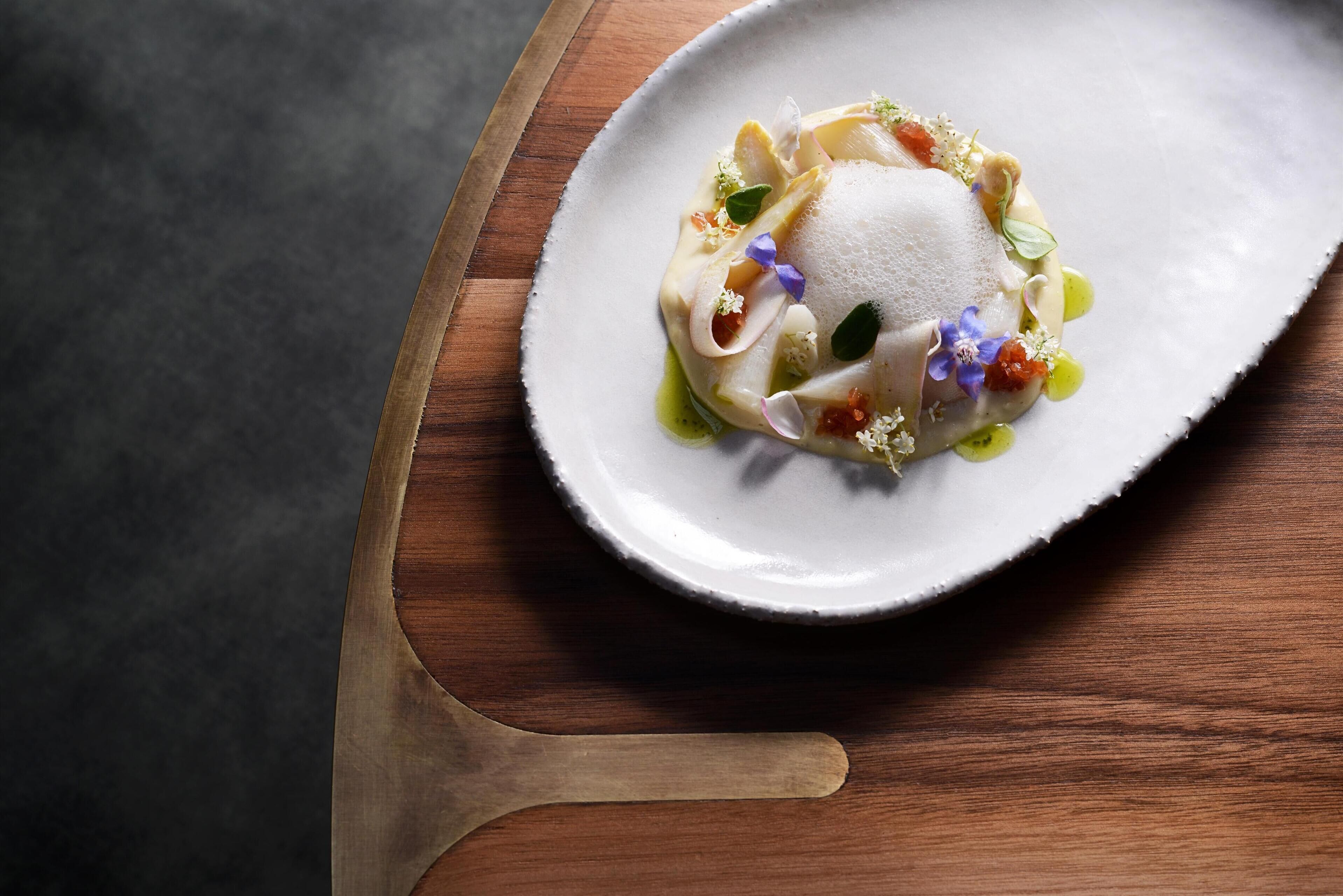Un plato blanco con un postre sobre una mesa de madera.