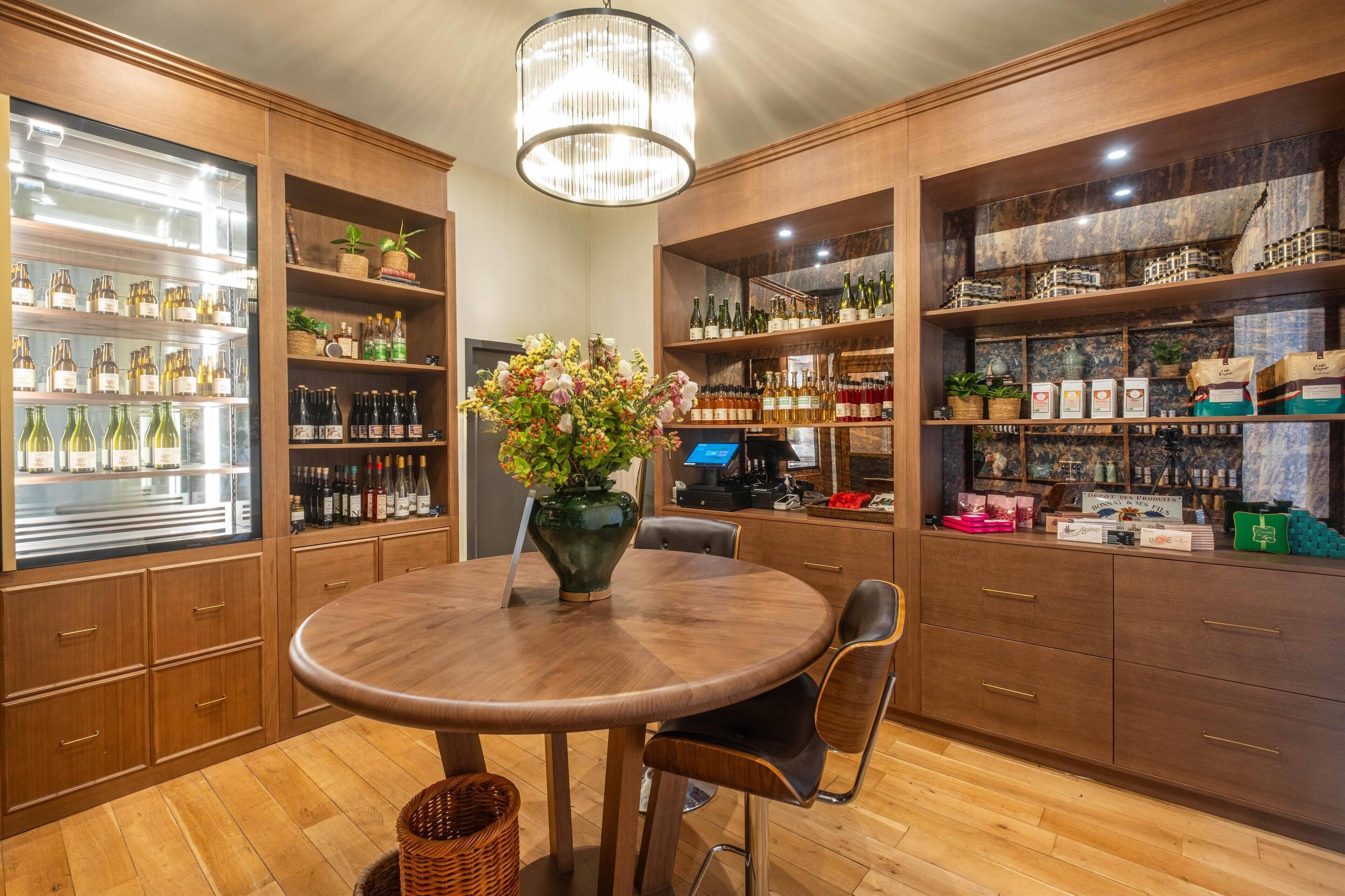 A spacious room with wooden cabinets, a round table, and a chandelier.