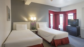A hotel room with two beds, a TV, a desk, and a chair. - Grant Plaza Hotel (San Francisco)