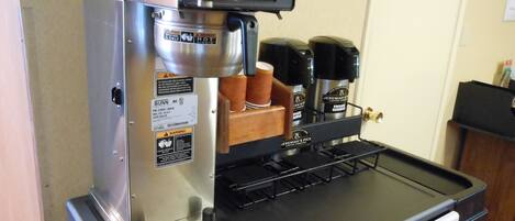 A commercial coffee machine with a control panel, a drip tray, and a coffee dispenser.