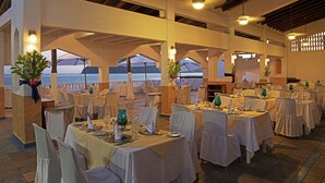 Un restaurant amb taules preparades per a dinar, amb vista a un conjunt d'aigua.