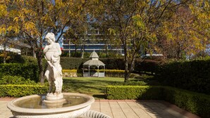Una statua in una fontana, un padiglione e un edificio sullo sfondo.