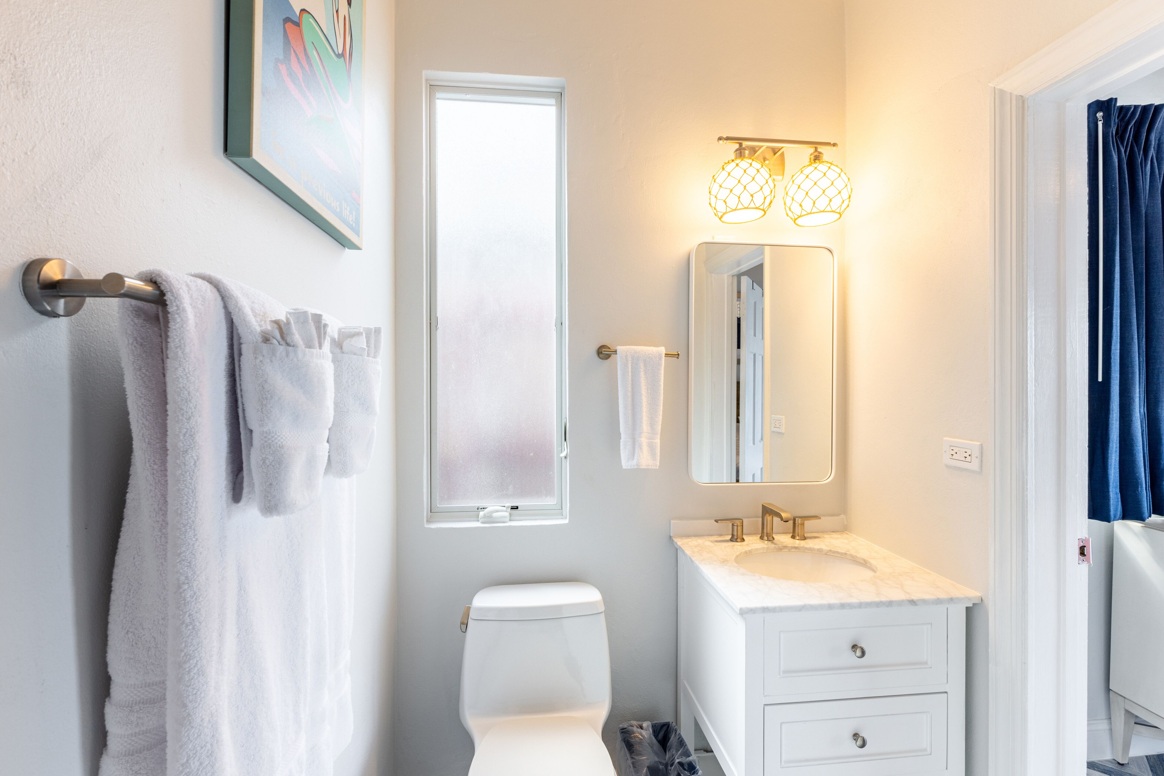 A modern bathroom with a toilet, sink, and towel rack.